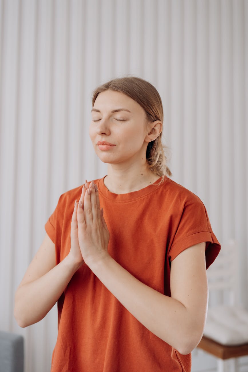 A woman in a peaceful state, stretching gently in a warmly lit room.